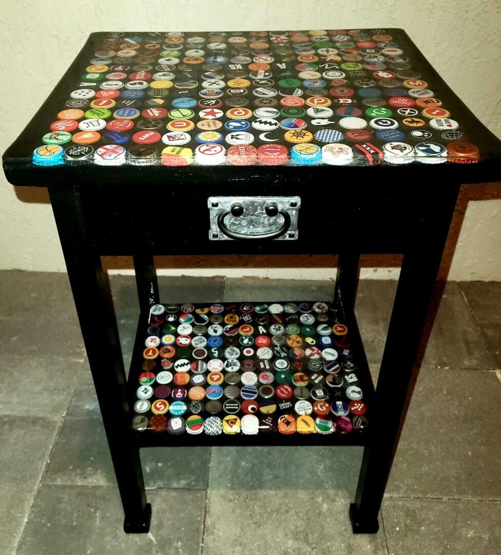 A table with a drawer and a shelf covered in bottle caps.