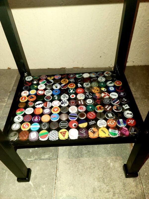 A chair with many different bottle caps on it