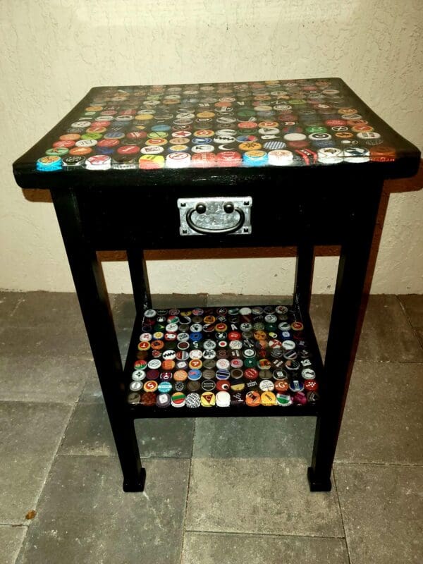 A table with a drawer and shelf made out of bottle caps.