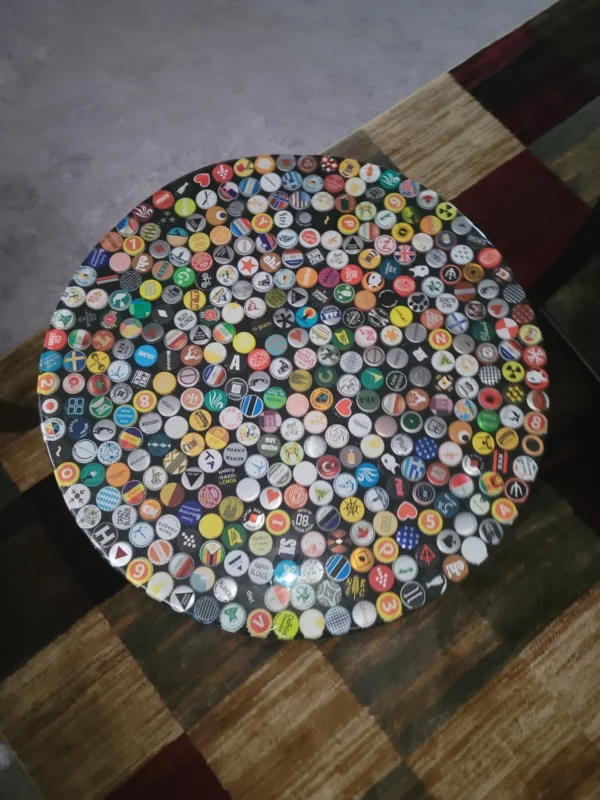 A table covered in many different colored bottle caps.