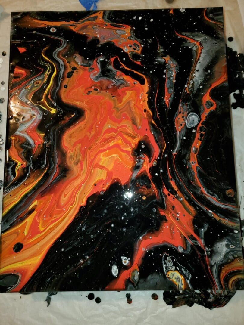 A painting of fire and black paint on the side.