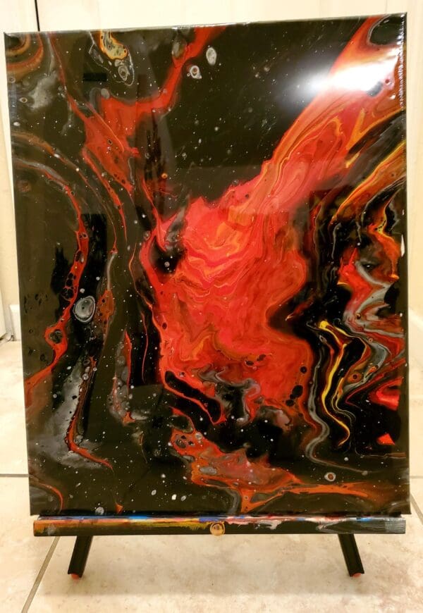 A painting of fire and black paint on the wall.