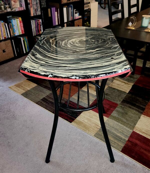 A table with black and red swirl design on top.