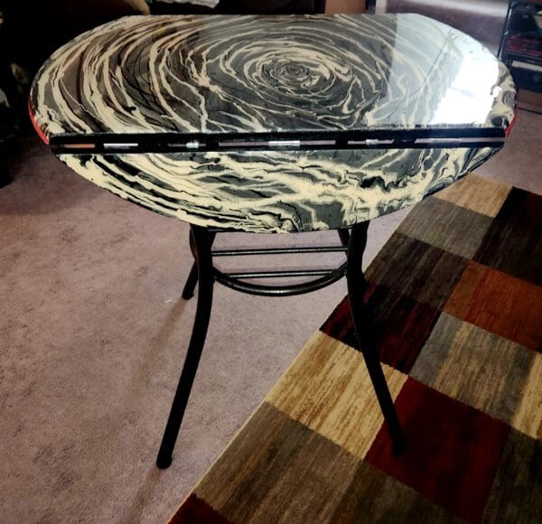 A table with a glass top and black metal legs.