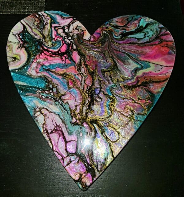 A heart shaped box with colorful swirls on it.