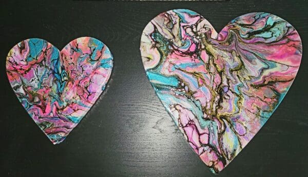 Two hearts that are made of paper and have a design on them.