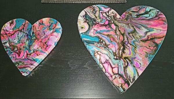 Two heart shaped pieces of art on a table.